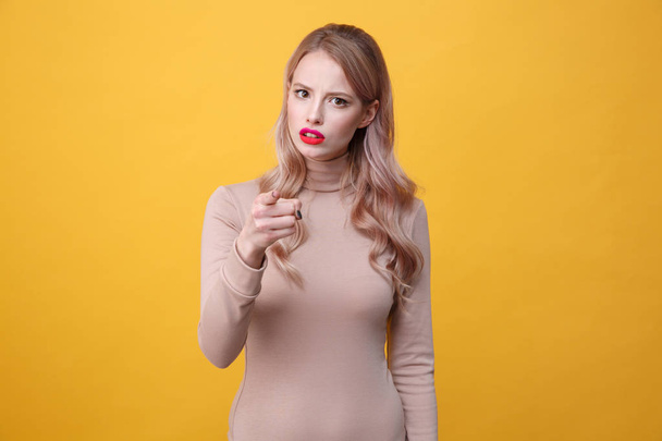 Confused young blonde lady with bright makeup lips pointing - Fotoğraf, Görsel