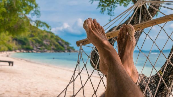 Men feet in Hammock, relaxing on the beach in Haad Rin, Ko Phangan - Photo, Image