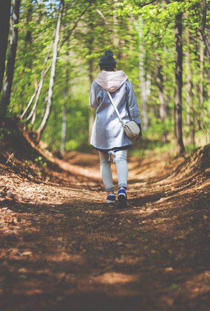 Young woman walking alone in early spring forest - Photo, image
