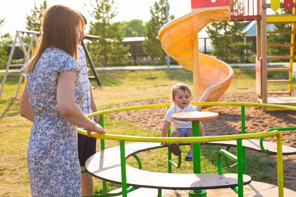 estate, infanzia, svago e concetto di famiglia bambino felice ei suoi genitori sulla cornice di arrampicata parco giochi per bambini
 - Foto, immagini