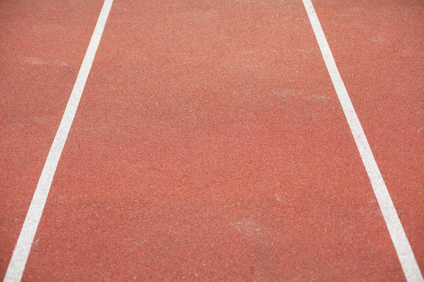 white bent lines marking red stadium with soft covering - Photo, Image