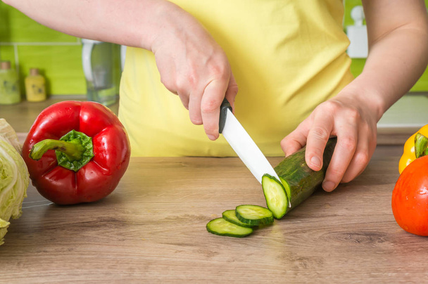 Woman cutting cucumber for salad - fresh vegetables concept - Fotoğraf, Görsel