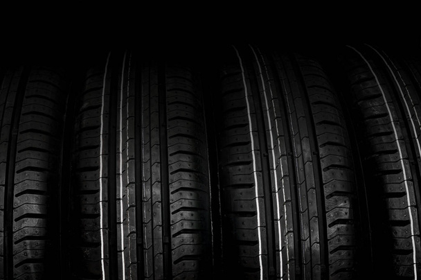 Автомобільні шини в ряд ізольовані на чорному
 - Фото, зображення