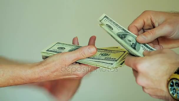 Wypłacanie gotówki od człowieka ręce licząc 100 banknotów dolarowych w ręce kobiety - Materiał filmowy, wideo