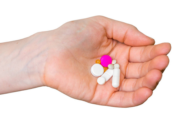 Stapel Pillen in weiblicher Hand isoliert auf weißem Papier - Foto, Bild