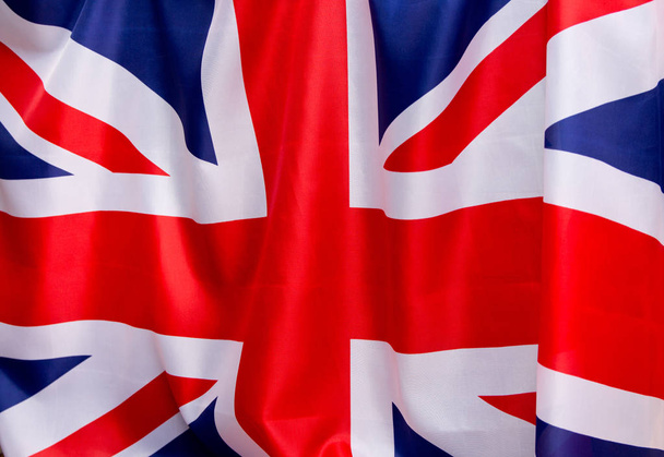 Brit zászló zuhan a szél. A hely, hogy reklámozni, sablon. - Fotó, kép