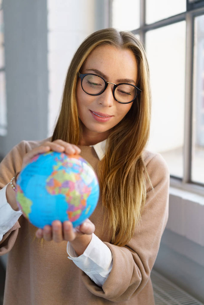 Young businesswoman holding a world globe - Foto, Imagen