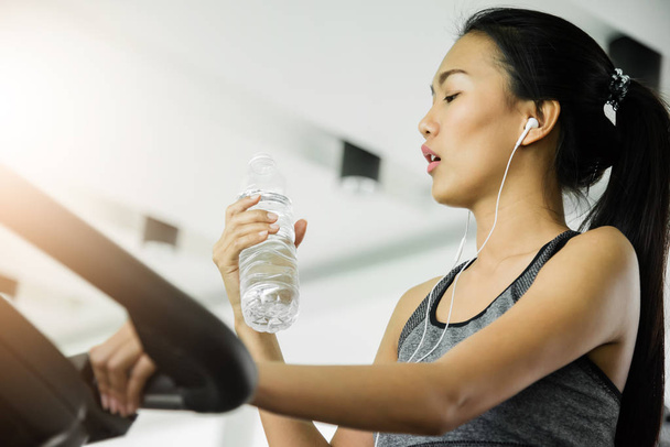 Asian woman in sportswear drinking water after workout at the gym. - Foto, Imagen