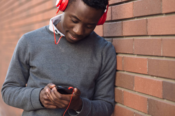 Hombre afroamericano escucha música en la ciudad
 - Foto, Imagen