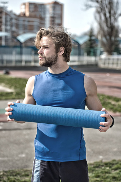 man with muscular body, beard holding yoga or fitness mat - Foto, immagini