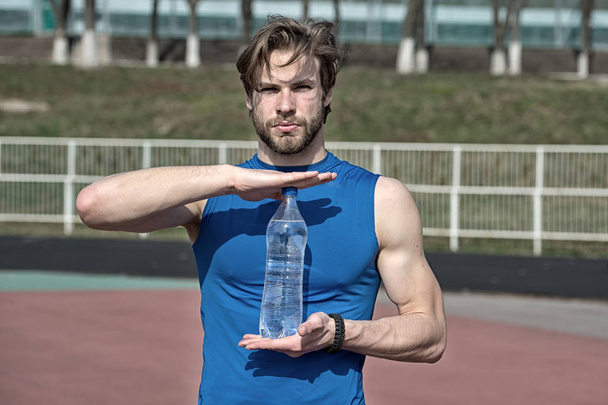 handsome muscular man holds water bottle - Zdjęcie, obraz