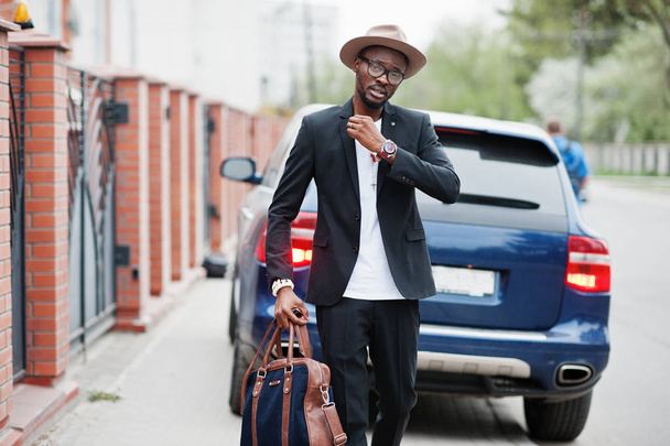 Stylish black man at glasses with hat, wear on suit with handbag - Foto, imagen