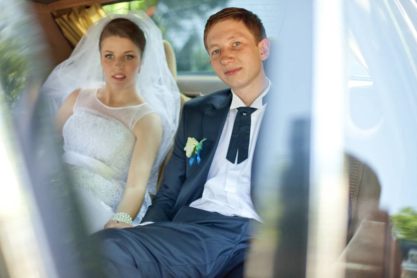 Look through the window on a wedding couple sitting on the back  - Photo, Image