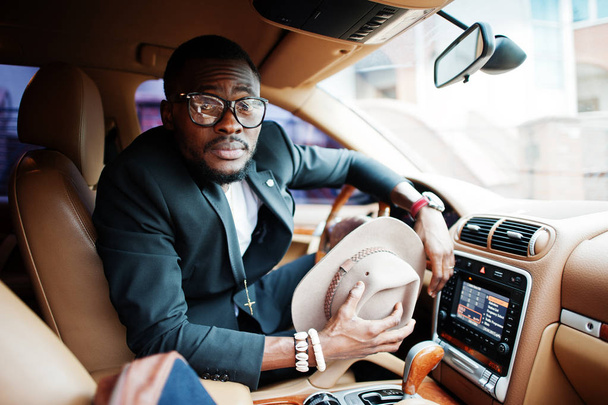 Stylish black man sitting behind the wheel of luxury car. Rich a - Foto, Bild