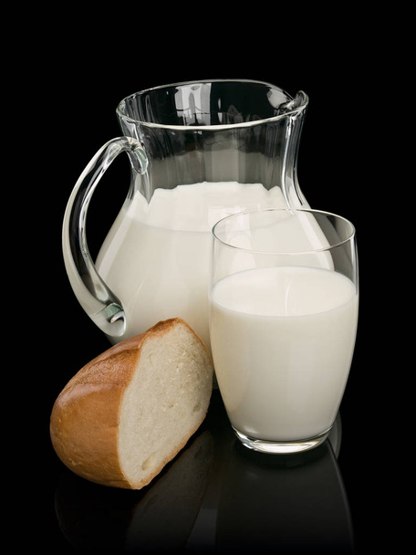 Piece of a white loaf and glassware filled with milk - Foto, Imagem
