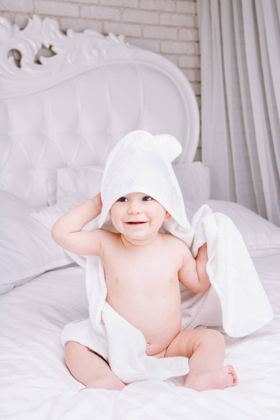 Elragadóan baby fehér törülközőt bed feküdj. Boldog gyermekkor és egészségügyi koncepció. - Fotó, kép