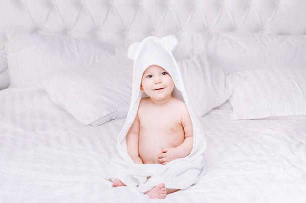 Adorably μωρό βρίσκονται σε λευκή πετσέτα στο κρεβάτι. Ευτυχισμένη παιδική ηλικία και υγειονομικής περίθαλψης έννοια. - Φωτογραφία, εικόνα