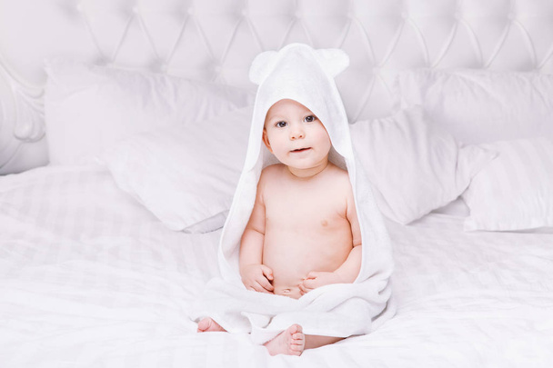 Adorably baby lie on white towel in bed. Happy childhood and healthcare concept. - Фото, изображение