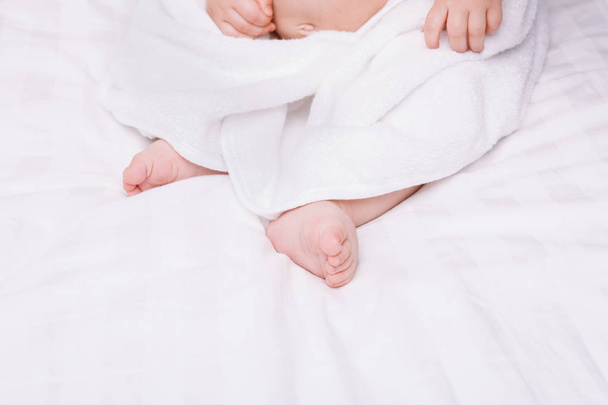 Adorably baby lie on white towel in bed. Happy childhood and healthcare concept. - Φωτογραφία, εικόνα