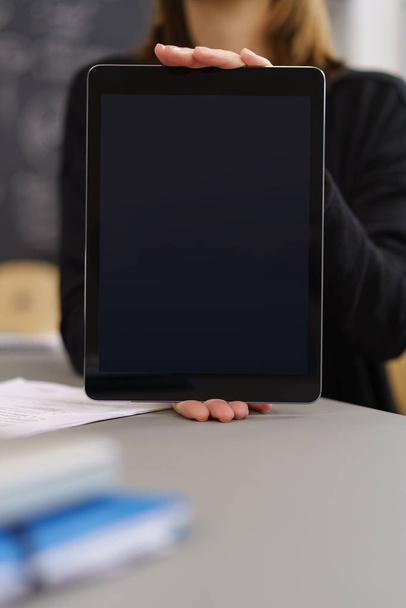 Businesswoman holding up a blank tablet pc - Foto, Bild
