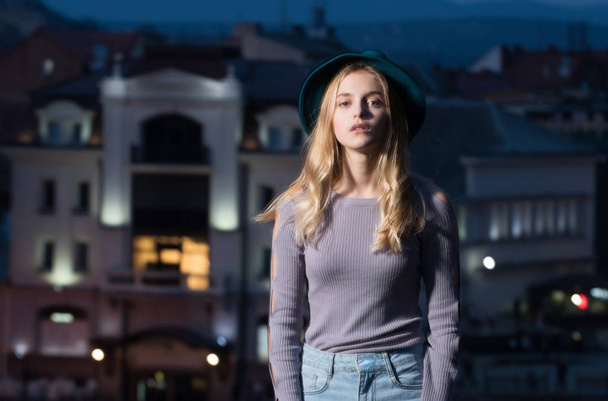 woman with hat in profile against night city background - Foto, imagen