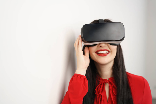 Young woman smiling as she enjoys VR goggles - 写真・画像