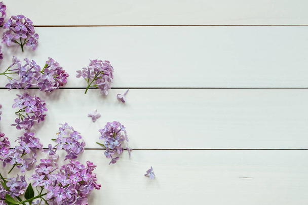 Flowers composition. Tender background. Beautiful fresh lilac flowers on wooden background - Photo, Image