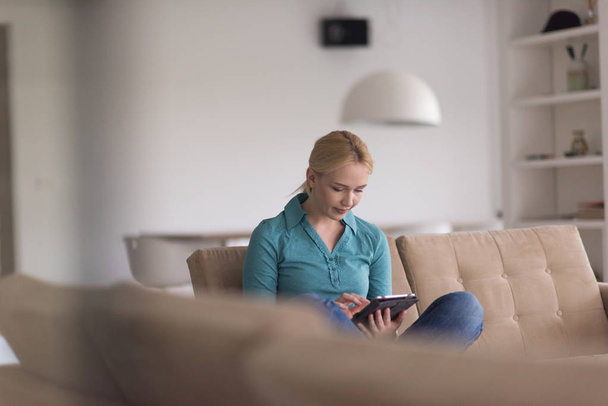 woman on sofa using tablet computer - 写真・画像