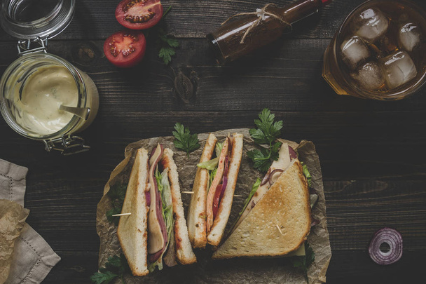 Fresh delicious club sandwich, sauces and drink on the wooden dark table - Fotoğraf, Görsel