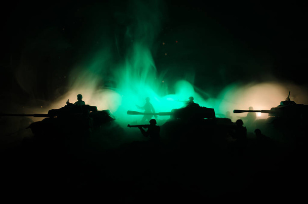 Koncepcja wojny. Wojskowych sylwetki walki scena na wojnie mgła niebo w tle, sylwetki żołnierzy wojny światowej poniżej zachmurzony Skyline w nocy. Scena ataku. Pojazdy opancerzone. - Zdjęcie, obraz
