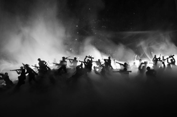 Concepto de guerra. Siluetas militares peleando escena en el fondo del cielo niebla de guerra, Soldados de la Guerra Mundial Siluetas debajo del horizonte nublado Por la noche. Escena de ataque. Vehículos blindados
. - Foto, imagen