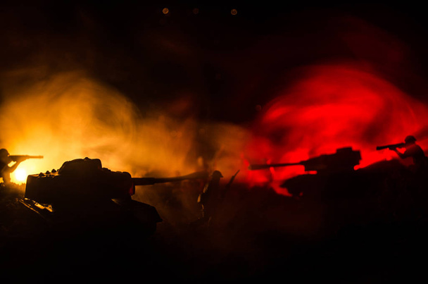 War Concept. Military silhouettes fighting scene on war fog sky background, World War Soldiers Silhouettes Below Cloudy Skyline At night. Attack scene. Armored vehicles. - Фото, изображение