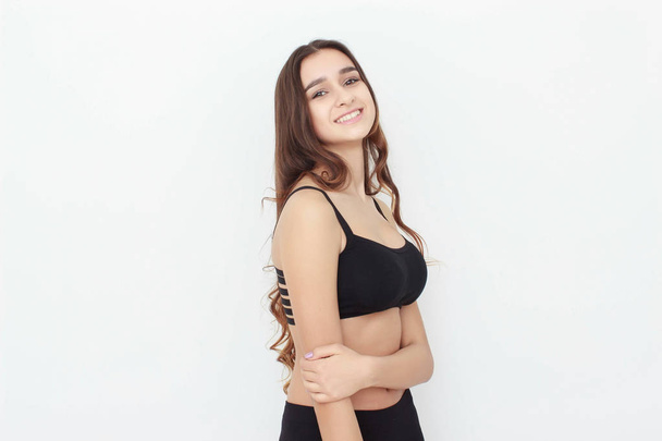 Beautiful girl in black top on white background shows emotion - Foto, immagini