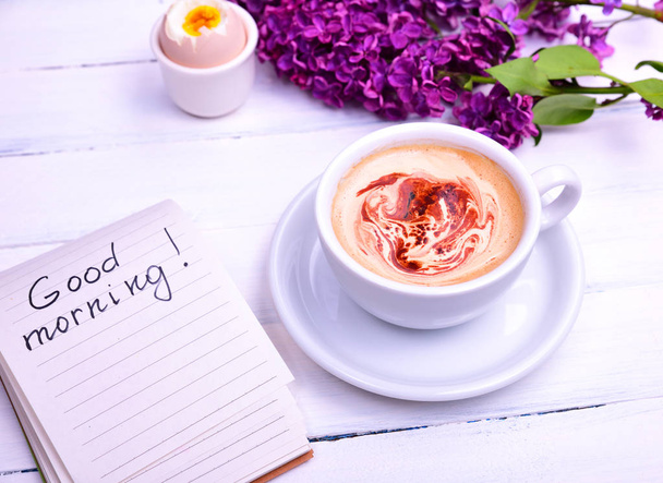 Cappuccino in a white cup, next note with the inscription good m - Photo, Image
