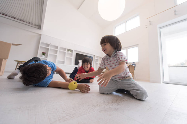 boys having fun with an apple on the floor - 写真・画像