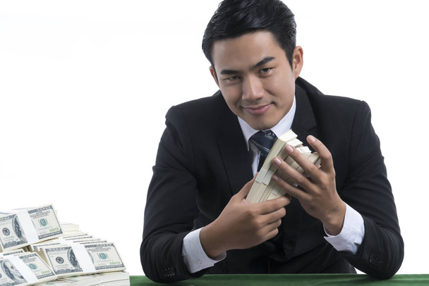 The young man holding piles of dollars in hand - Φωτογραφία, εικόνα