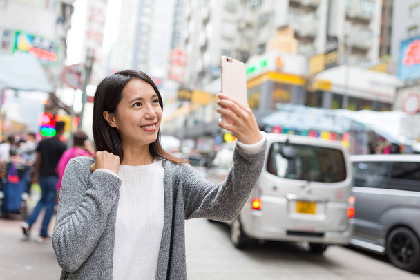 Woman taking selfie in Mongkok city - Photo, Image