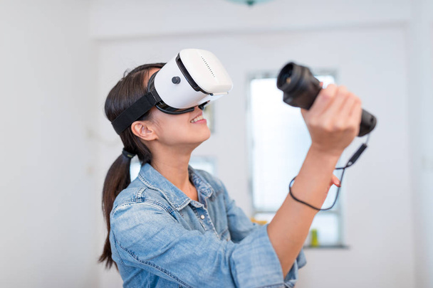 Жінка грає в гру з пристроєм VR
 - Фото, зображення