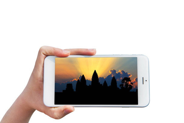 Hand holding Smartphone with image of Angkor Wat Temple, Siem reap in Cambodia. - Φωτογραφία, εικόνα