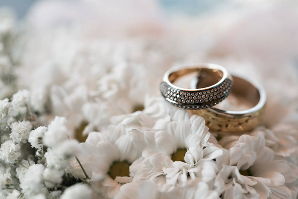 Anneaux de mariage sur un oreiller de fleurs blanches. accessoires mariage gros plan. focus sélectif
 - Photo, image