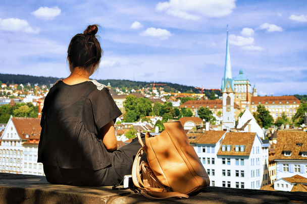 Chica sentada en la colina Lindenhof y mirando a Zurich
 - Foto, imagen