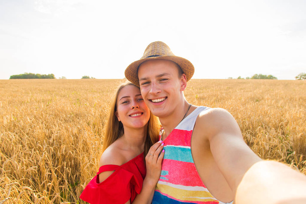 Mladý šťastný pár s selfie v poli - Fotografie, Obrázek