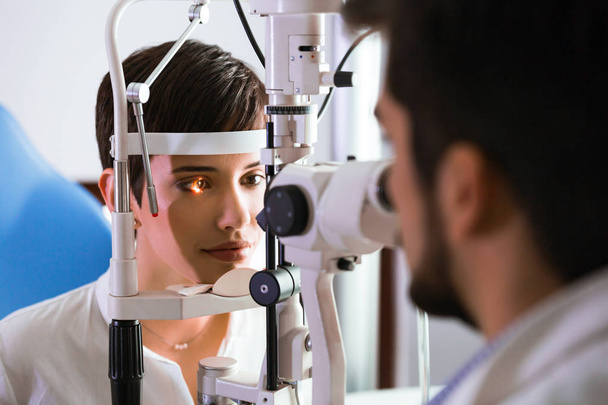 optometrist checking patient eyesight - 写真・画像