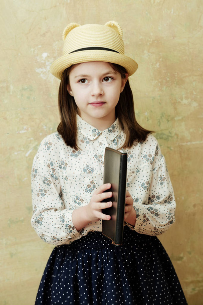 girl holding black note book in retro hat - Foto, afbeelding