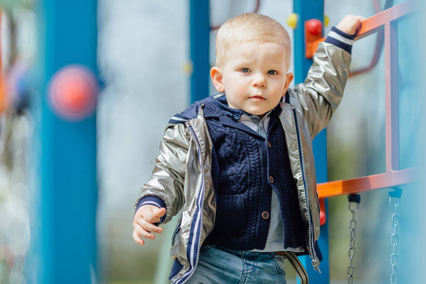 Little boy riding a swing in park playground - Foto, Bild