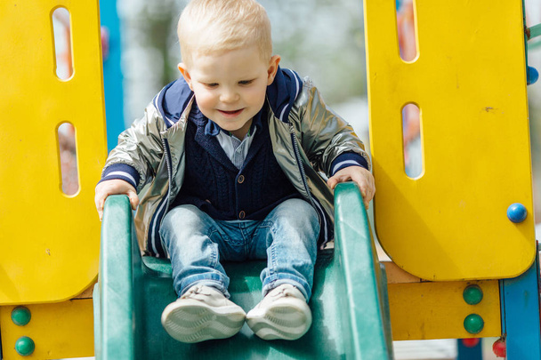 Little boy riding a swing in park playground - Zdjęcie, obraz