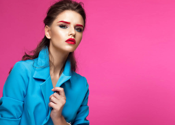 Beautiful girl in blue suit on pink background with creative make-up and fashionable style. Beauty face. - Zdjęcie, obraz