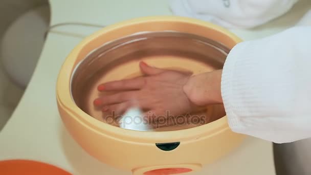 tratamiento de parafina proceso de manos femeninas en salón de belleza - Imágenes, Vídeo