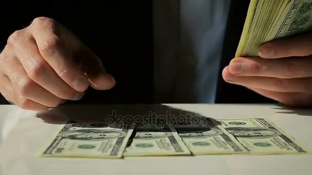 Férfi öltöny határozza meg az asztalon száz dollár számlák - Felvétel, videó