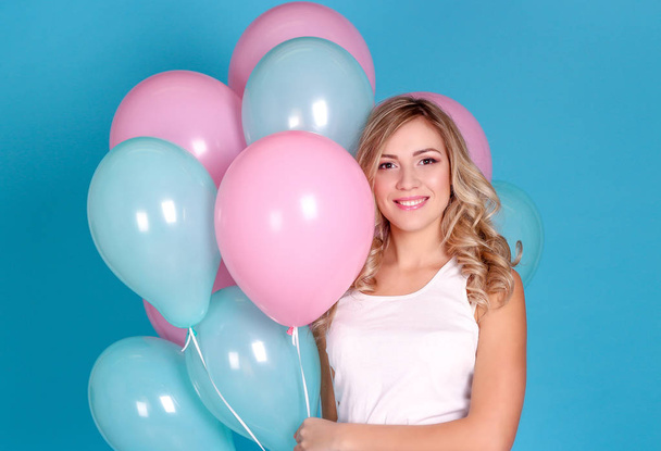 Young beautiful blonde girl holding balloons. Studio. Woman holding colorful balloons. Birthday. - Foto, imagen